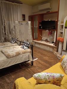 a living room with two beds and a flat screen tv at B&B Coccinella in Basiliano