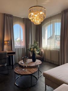 ein Wohnzimmer mit einem Bett und einem Tisch mit einer Couch in der Unterkunft Hotel Belvedere in Warnemünde