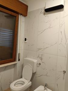 a white bathroom with a toilet and a sink at B&B Coccinella in Basiliano