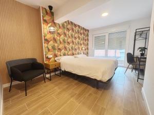 a bedroom with a bed and a desk and a chair at La SIGRINA Tuy in Tui