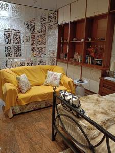 a living room with a yellow couch in a room at B&B Coccinella in Basiliano +9 photos