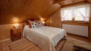 a small bedroom with a bed and a window at Mały Domek in Stara Rzeka