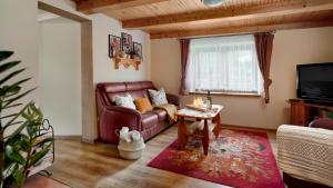 a living room with a couch and a tv at Mały Domek in Stara Rzeka