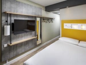 a bedroom with a bed and a flat screen tv at ibis budget Swindon Town Centre in Swindon +48 photos