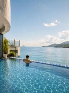 a person in a swimming pool overlooking the water at Prime New Hotel in Nha Trang