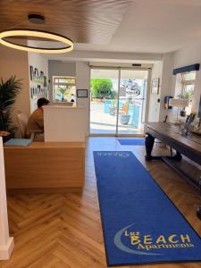 an office with a blue rug in the middle of a room at Luz Beach Apartments in Luz