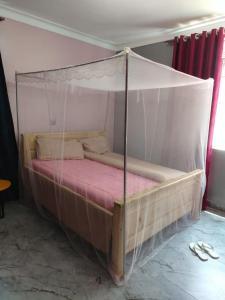 a bed with a canopy in a room at E- Gem in Gulu