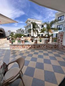 a patio with a chair and a checkered floor at Vila Reni Risi in Ksamil