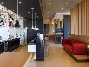 a restaurant with a red couch and a bar at ibis Tatui in Tatuí