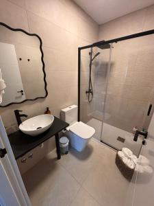 a bathroom with a sink and a toilet and a shower at La SIGRINA Tuy in Tui