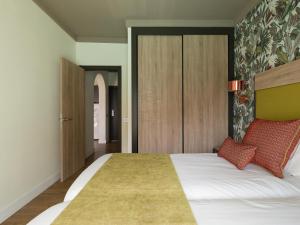 a bedroom with a large white bed with red pillows at Servatur Doña Elvira in Puerto Rico de Gran Canaria