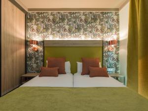 a bedroom with a white bed with a green headboard at Servatur Doña Elvira in Puerto Rico de Gran Canaria