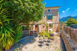 a stone cottage with a table and chairs at Can Raia in Sóller