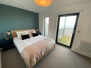 a bedroom with a large bed and a large window at Residence Number 5 - Luxury 2 Bed Ground Floor Apartment By Together Travel in Nefyn