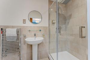a bathroom with a sink and a shower with a mirror at Residence Number 5 - Luxury 2 Bed Ground Floor Apartment By Together Travel in Nefyn +9 photos