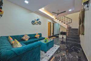 a living room with a blue couch and stairs at II EMPYREAN STAYS II AURA VILLA II 3BHK II AC II LARGE POOL Il in Lonavala