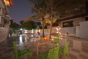 a table and chairs on a patio at night at II EMPYREAN STAYS II AURA VILLA II 3BHK II AC II LARGE POOL Il in Lonavala