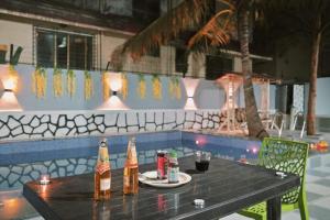 a table with two bottles of beer on it at II EMPYREAN STAYS II AURA VILLA II 3BHK II AC II LARGE POOL Il in Lonavala