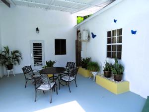 a patio with a table and chairs and plants at Artist Room Curaçao in Willemstad