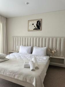 a bedroom with a white bed with towels on it at HILLIUS Resort in Solotvyno +55 photos