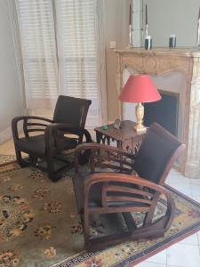 a living room with two chairs and a table with a lamp at Villa Meyer Demeure Remarquable chambre d'hôtes,Art Déco,standing in Béziers