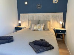 a bedroom with a large white bed with two lamps at Résidence le 1564 Bleu in Roussillon en Isere