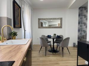 a kitchen with a sink and a table with chairs at Sopianae Apartments in Pécs