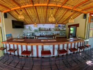 a bar in a restaurant with red bar stools at Muchenje River Lodge in Katima Mulilo