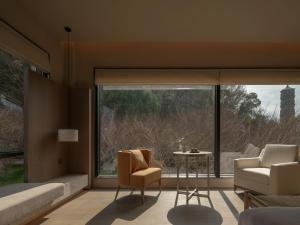 a room with a large window with two chairs and a table at Hayama Pagoda Villa in Taizhou