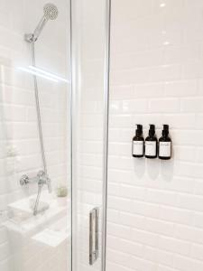a bathroom with a shower with two bottles of wine at Grand Central House - Deluxe Studio - GibraltarStay Apartments in Gibraltar +15 photos