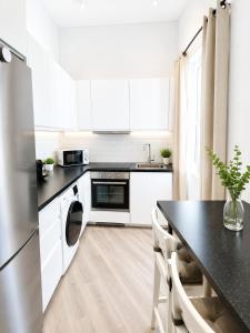 a kitchen with white cabinets and a black counter top at Grand Central House - Deluxe Studio - GibraltarStay Apartments in Gibraltar