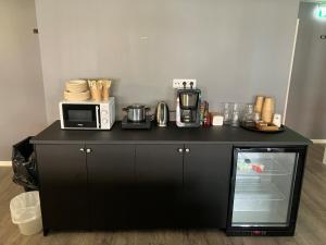a black counter with a microwave and appliances on it at Nordsjögården in Järvsö