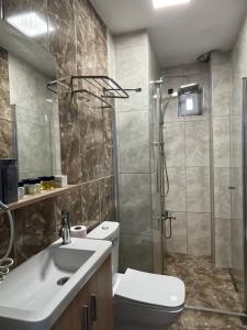 a bathroom with a shower and a toilet and a sink at Parli Hotel in Gokceada Town