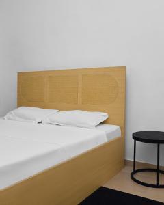 a bed with a wooden headboard and a table at IGBADUN House in Godomey