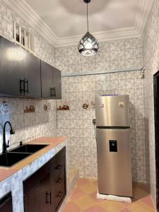 a kitchen with a refrigerator and a sink at IGBADUN House in Godomey