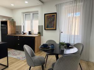 a living room with a table and chairs and a kitchen at Sopianae Apartments in Pécs