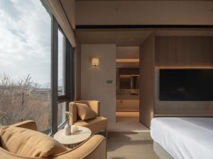 a hotel room with a bed and a large window at Hayama Pagoda Villa in Taizhou