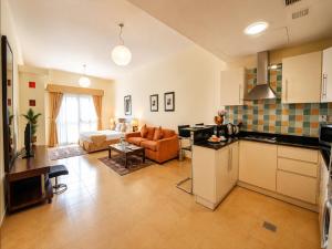 a large kitchen and living room with a couch at Tulip Hotel Apartments in Dubai
