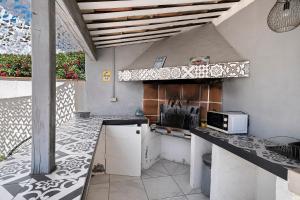 an outdoor kitchen with a counter and a microwave at Les Arbousiers in Saint-Raphaël