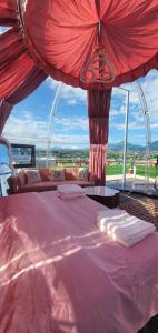 a bedroom with a large bed with a large window at Maremonti Glamping in Ancarano