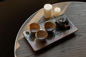 a tray with four cups on a table with candles at Hayama Pagoda Villa in Taizhou