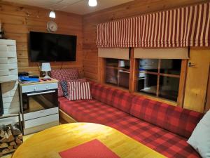 a living room with a red couch and a tv at Kutusumppu A in Tahkovuori