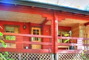 a red log cabin with a red fence at Kutusumppu A in Tahkovuori