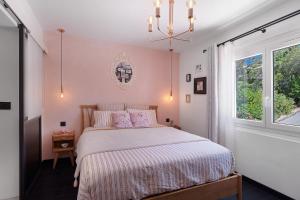 a bedroom with a bed with pink walls and a window at Les Arbousiers in Saint-Raphaël +32 photos
