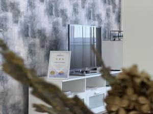 a room with a tv and a sign on a table at Sopianae Apartments in Pécs