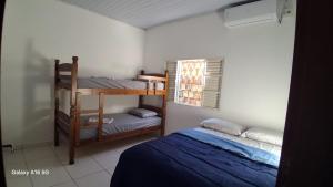 a bedroom with two bunk beds and a window at Casa de férias Pôr do Sol 4 in Bataguaçu