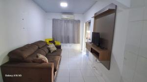 a living room with a couch and a flat screen tv at Casa de férias Pôr do Sol 4 in Bataguaçu