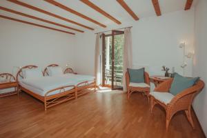 a bedroom with a bed and two chairs and a table at Hotel Sass da Grüm in Vairano