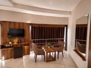 a hotel room with a table and chairs and a television at Star Hotel in Ahmedabad