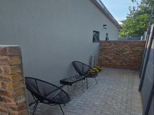two chairs and a table on a brick patio at Grand Diamond Lodge in Roodepoort